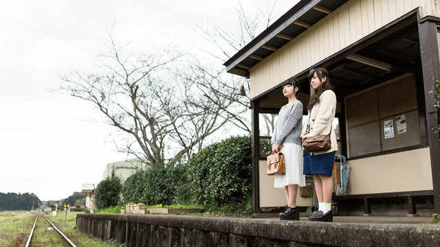 駅で立つ女性の写真