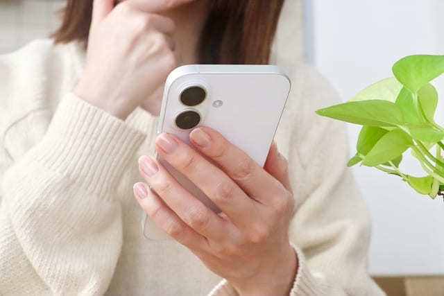 名古屋探偵事務所に相談する前にスマホで確認する女性