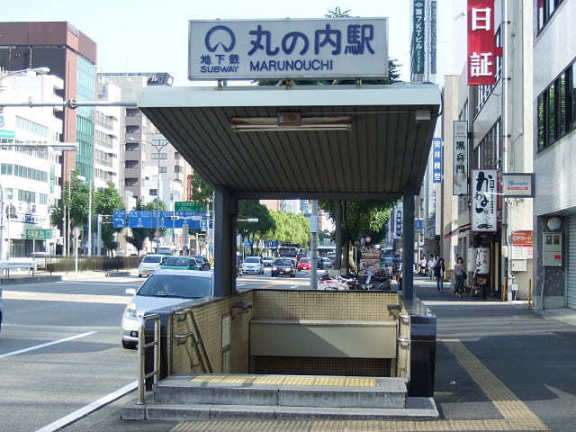 地下鉄丸の内駅8番出口の写真で、名古屋探偵事務所へ徒歩約2分で向かえるアクセスの起点を示す画像。階段を降りる駅入口が写されており、来所までの流れをわかりやすく案内するための視覚的な目印となる写真。